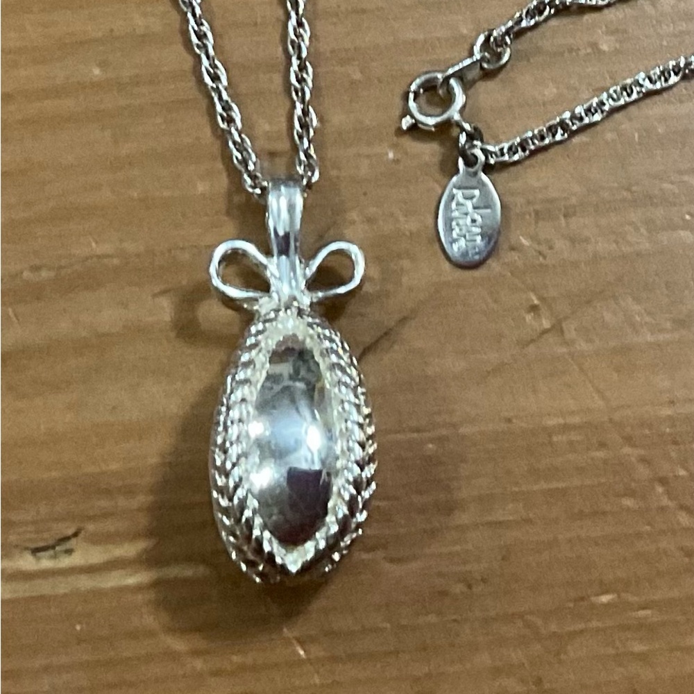 Joan Rivers: 15” Silver toned/plated Faberge style egg bow pendant and chain.